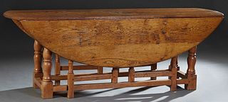 English Carved Oak Wake Table, early 20th c., the two oval drop leaves on turned tapered and block gate legs, on block feet, H.- 29 1/4 in., W.- 83 3/