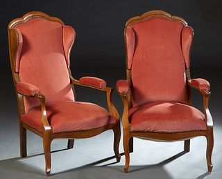 Pair of Louis Philippe Carved Cherry Wing Chairs, 19th., the arched upholstered backs with two wings, over upholstered arms and a bowed seat, on cabri