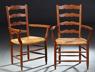Pair of French Provincial Carved Cherry Rush Seat Armchairs, early 20th c., with serpentine horizontal ladder backs, to curved flat arms, over a bowed