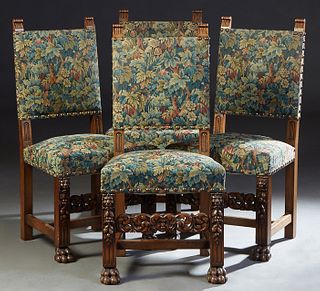 Set of Four French Provincial Carved Oak Dining Chairs, 20th c., the upholstered high back a over trapezoidal cushioned seat, on lions' head, fruit an