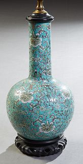 Chinese Porcelain Bottle Form Vase, early 20th c., with floral decoration on an aqua ground, now with a carved wooden top and stand, wired as a lamp, 
