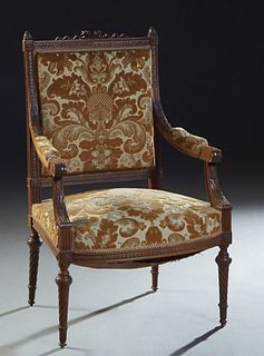 French Carved Walnut Louis XVI Style Fauteuil, 20th c., with a pierced bow and ribbon crest over an upholstered back and upholstered arms, to a bowed 