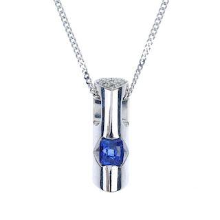 A sapphire and diamond pendant. The cushion-shape sapphire, inset to the tapered bar, with brilliant