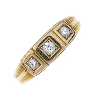 A late Victorian 18ct gold diamond three-stone ring. The graduated old-cut diamond line, to the groo