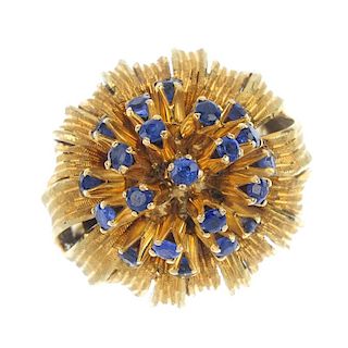 A mid 20th century 18ct gold sapphire flower ring. The circular-shape sapphire spray, within a textu