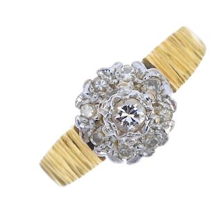 A 1970s 18ct gold diamond cluster ring. The brilliant-cut diamond, within a similarly-cut diamond su