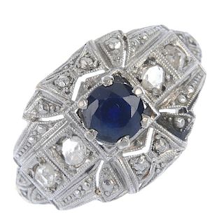 A sapphire and diamond cocktail ring. The circular-shape sapphire, within a rose-cut diamond geometr