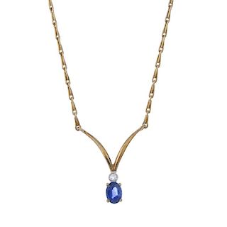 A 9ct gold sapphire and diamond pendant. The oval-shape sapphire, to the brilliant-cut diamond colle