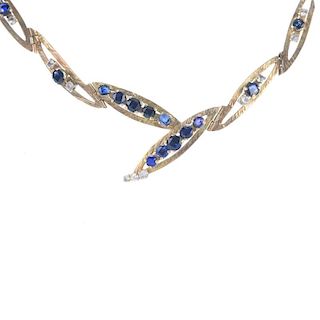 A 9ct gold sapphire and paste necklace. Designed as a series of marquise-shape textured links, with