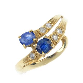 A sapphire and diamond dress ring. The oval-shape sapphire and brilliant-cut diamond scrolling band,