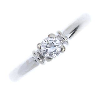 A diamond single-stone ring. The brilliant-cut diamond, to the crossover gallery, bar shoulders and