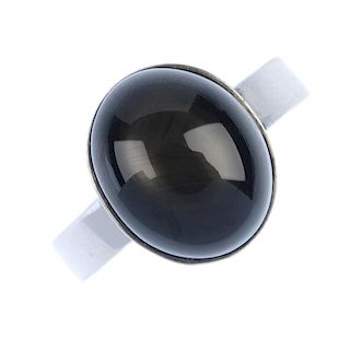 A star sapphire ring. The oval brown star sapphire cabochon, to the plain band. Weight 7.3gms. <br><