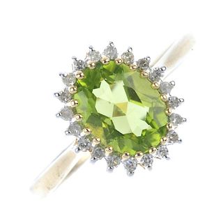 A 9ct gold peridot cluster ring. The oval-shape peridot, within a single-cut diamond surround, to th