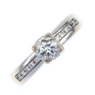 A diamond single-stone ring. The brilliant-cut diamond, raised to the similarly-cut diamond line sho