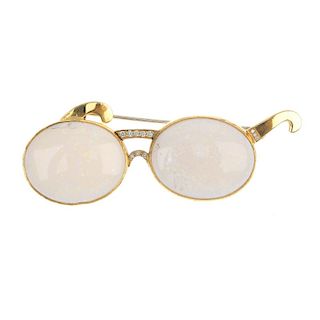 An 18ct gold opal and diamond novelty brooch. Designed as a pair of spectacles. The oval opal caboch