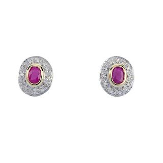 A pair of 9ct gold ruby and diamond cluster ear studs. Each designed as an oval-shape ruby, within a