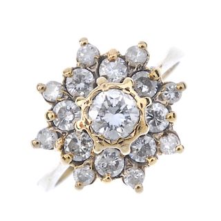 A 9ct gold diamond cluster ring. The brilliant-cut diamond, within a similarly-cut diamond stylised