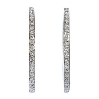 Two pairs of diamond earrings. The first pair each designed as a brilliant-cut diamond curved line,
