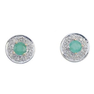 A pair of 9ct gold emerald and diamond cluster ear studs. The circular-shape emerald, within a singl