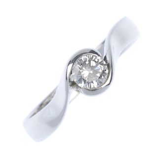 An 18ct gold diamond single-stone ring. The brilliant-cut diamond, to the asymmetric shoulders and p