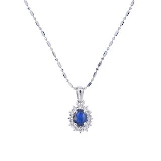 A sapphire and diamond cluster pendant. The oval-shape sapphire, within a brilliant-cut diamond surr