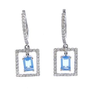 A pair of topaz and diamond ear pendants. Each designed as a rectangular-shape blue topaz, suspended