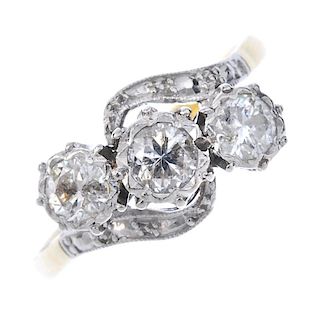 An 18ct gold diamond three-stone ring. The brilliant-cut diamond, illusion-set diamond diagonal line