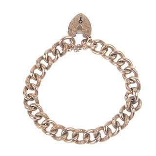 An Edwardian 9ct gold bracelet. The alternate scrolling foliate embossed and polished curb-link chai