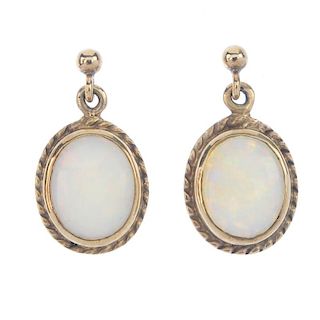 A pair of opal ear pendants and a 9ct gold opal ring. The ear pendants each designed as an oval opal