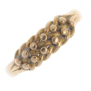 An early 20th century 18ct gold keeper ring. The bead and interwoven curb-link panel, to the grooved