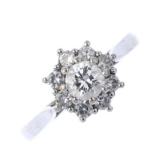 An 18ct gold diamond cluster ring. The brilliant-cut diamond, raised within a similarly-cut diamond