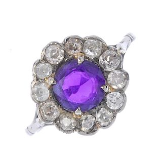 An amethyst and diamond cluster ring. The circular-shape amethyst, within an old-cut diamond scallop