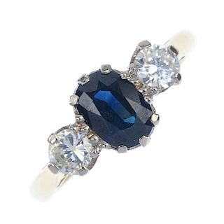 A mid 20th century 18ct gold sapphire and diamond three-stone ring. The oval-shape sapphire, with br
