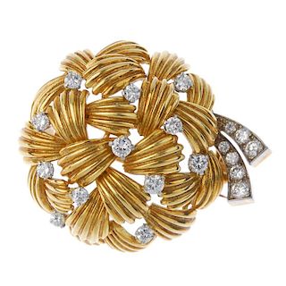 A 1970s 18ct gold diamond brooch. The stylised rosette, comprising of scalloped panels, with brillia