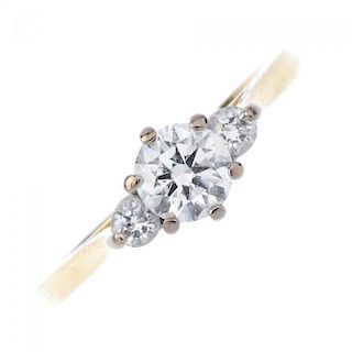 An 18ct gold diamond ring. The brilliant-cut diamond, with similarly-cut diamond sides, to the plain