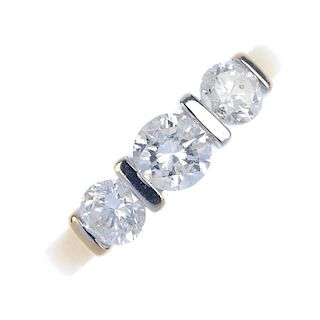 An 18ct gold diamond three-stone ring. The graduated brilliant-cut diamond line, with bar spacers, t
