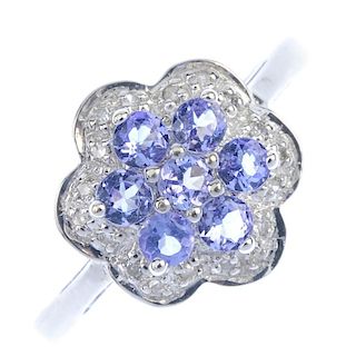 A 9ct gold tanzanite and diamond floral cluster ring. The circular-shape tanzanite cluster, within a