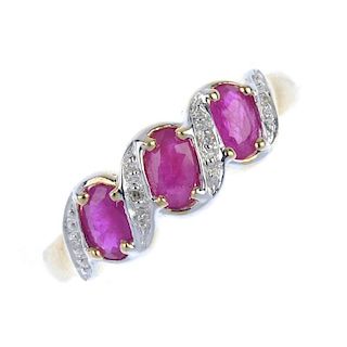 A 9ct gold ruby and diamond dress ring. The oval-shape ruby line, between bi-colour curved line diam