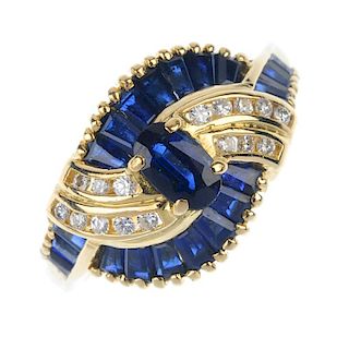 An 18ct gold sapphire and diamond dress ring. The oval-shape sapphire, within a tapered baguette-cut