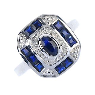A 9ct gold sapphire and diamond dress ring. The oval-shape sapphire collet, within an illusion-set d