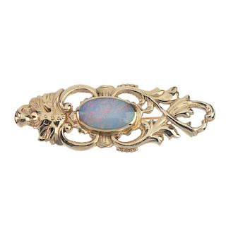 A 9ct gold opal doublet brooch. The oval opal doublet cabochon, within an openwork foliate surround.
