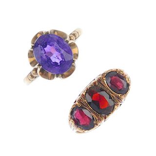 A selection of four gem-set rings. To include a 9ct gold topaz ring, a 9ct gold garnet three-stone r