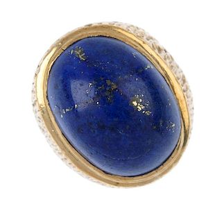 A gentleman's 1970s 9ct gold lapis lazuli ring. The oval lapis lazuli cabochon, to the textured band