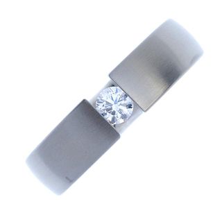 A gentleman's diamond single-stone ring. The brilliant-cut diamond, tension-set to the textured band