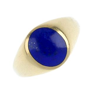 An 18ct gold lapis lazuli signet ring. The oval lapis lazuli panel, to the tapered shoulders and pla