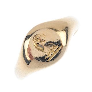 An early 20th century 18ct gold signet ring. The circular panel, depicting a crest, to the plain ban