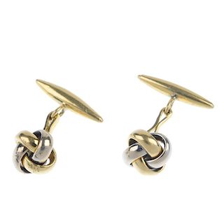 A pair of knot cufflinks. Each designed as a bi-colour knot, with torpedo reverse and connecting bar