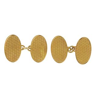 A pair of 1920s 18ct gold cufflinks. Each designed as two textured oval-shape panels, with connectin