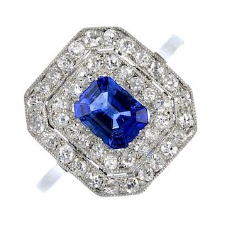 An early 20th century platinum sapphire and diamond cluster ring. The rectangular-shape sapphire, wi
