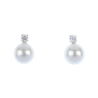 A pair of diamond and cultured pearl ear pendants. Each designed as a cultured pearl, measuring appr